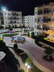 a courtyard with a fountain and buildings at night at Tahiti North coast kilo 62 in Borg El Arab