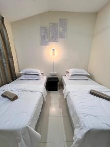 two beds sitting next to each other in a room at MiD Guest House in Gambang