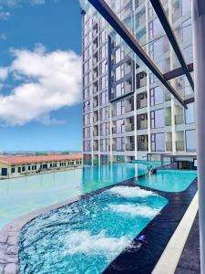 a swimming pool in front of a tall building at Maison Joie Ecopark Lighthouse Ecorivers Hải Dương in Hải Dương