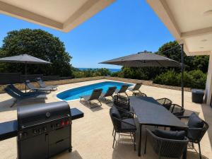 a patio with a table and chairs and a swimming pool at Villa LiRa Star Bar Montenegro - Exclusive Adriatic Villa with Private Pool Starry Sky Lounge in Stari Ulcinj