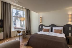 a hotel room with a bed and a window at Carillon Aparthotel - Keystone Collection, opened December 2025 in Riga