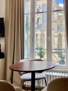 a table and chairs in front of a large window at La Cathédrale in Soissons
