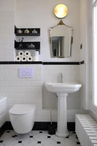 a white bathroom with a sink and a toilet at La Cathédrale in Soissons +9 photos