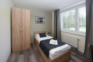 a bedroom with a bed and a cabinet and a window at Hotel Prokopávka in Pilsen +31 photos