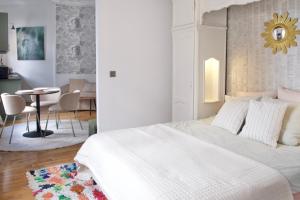 a bedroom with a white bed and a dining room at La Cathédrale in Soissons