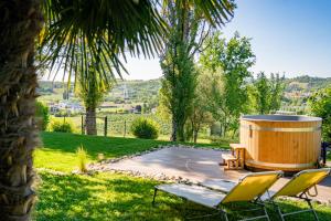 a large wooden barrel in a yard with chairs at Il Casotto tra i Vigneti in Nizza Monferrato