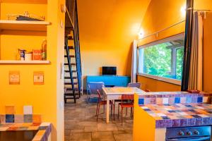 a kitchen with yellow walls and a table and chairs at Il Casotto tra i Vigneti in Nizza Monferrato +24 photos
