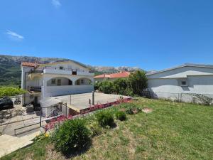 a small house with a yard and a house at Apartments Drita in Baška
