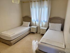 two beds in a room with a window at Calma in Beni Mellal
