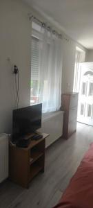 a bedroom with a bed and a desk and a window at Gábor - lak in Miskolc