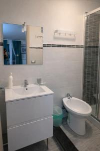 a white bathroom with a sink and a toilet at BlueSkyLite in Taormina