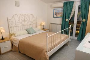 a bedroom with a white bed and green curtains at BlueSkyLite in Taormina