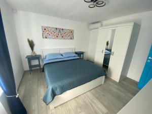a bedroom with a blue bed and a mirror at Casa Feodor in Jurilovca