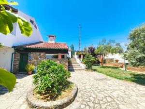 a house with a stone pathway next to a building at Casa da Torre in Sao Pedro de Tomar