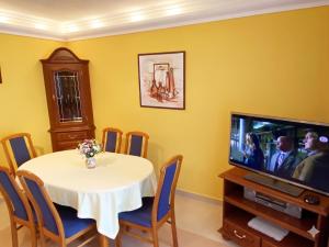 a dining room with a table and a tv at Furedi Apartman in Balatonfüred