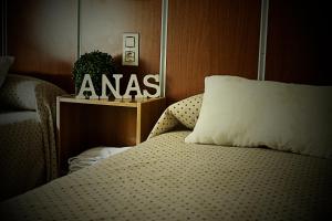 1 dormitorio con 1 cama y un cartel en la pared en Hostal Anas, en Mérida