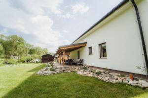 a white house with a grass yard at Prázdninový dům Sobotín in Sobotín