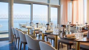a restaurant with tables and chairs and large windows at Willow, WorldHotels Crafted in Trelleborg