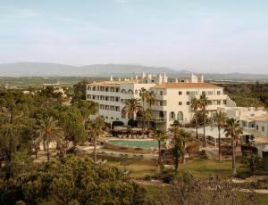 an aerial view of a resort with a pool and palm trees at Vale d'El Rei Hotel & Villas in Carvoeiro