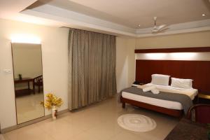 a hotel room with a bed and a mirror at Dhanunjayas Luxury Hotel in Hosūr +63 photos