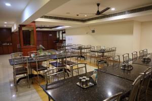 an empty banquet hall with tables and chairs at Dhanunjayas Luxury Hotel in Hosūr