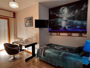 a bedroom with a desk and a large screen on the wall at La Casa del Benessere in Campobasso