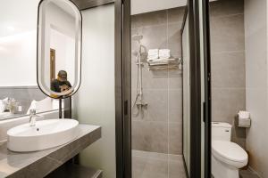 a man taking a picture of a bathroom at Vui Hotel in Sầm Sơn +10 photos