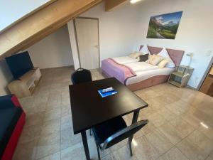 a room with a bed and a table in a room at HotelPension Weberhof in Ebersberg