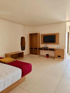 a bedroom with a bed and a flat screen tv at Trivera in Pidugurālla