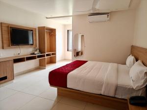 a hotel room with a bed and a television at Trivera in Pidugurālla