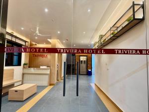 a lobby of a hotel with a sign on the wall at Trivera in Pidugurālla