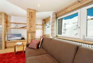 a living room with a couch and windows at Maison Rêve Blanc - Panoramic Ski in - Ski out in Breuil-Cervinia