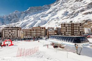 a snow covered city with buildings and a mountain at Maison Rêve Blanc - Panoramic Ski in - Ski out in Breuil-Cervinia