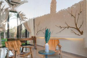 a room with two chairs and a table with a plant on it at Luxury Marrakech Villa marrakech pool,staff,brekfast included in Marrakesh
