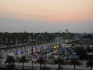 a parking lot with a park with palm trees and lights at Vui Hotel in Sầm Sơn