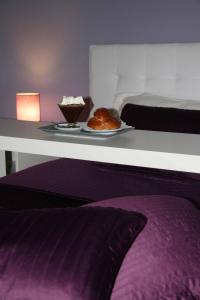 ein Schlafzimmer mit einem Tisch mit einem Teller Essen in der Unterkunft Modica Suite in Modica