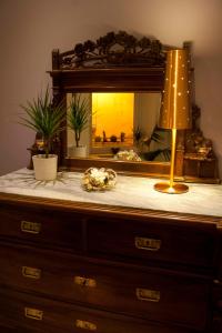 a dresser with a lamp on it with a mirror at Modica Suite in Modica