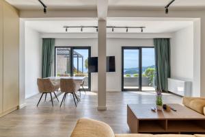 a living room with a couch and a table and chairs at Quercus Villa 2 in Blizikuće
