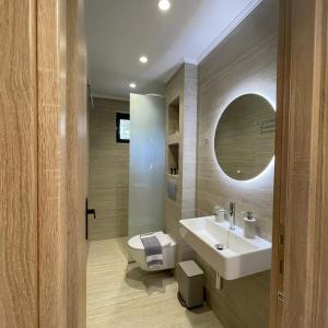 a bathroom with a white sink and a mirror at Μπουκαμβίλια - Bougainvillea in Sivota +22 photos