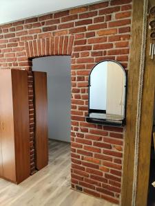 a brick wall with a mirror on it at Apartamentai Heydekrug in Šilutė
