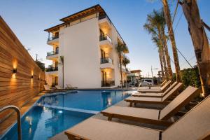 a swimming pool with lounge chairs next to a building at Hotel Mare 2 in Ksamil