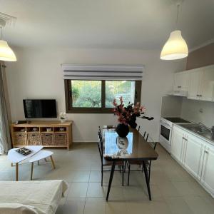 a living room with a table and a kitchen at Μπουκαμβίλια - Bougainvillea in Sivota
