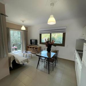a kitchen and living room with a table and chairs at Μπουκαμβίλια - Bougainvillea in Sivota