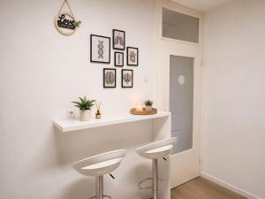 a white bar in a white room with two stools at Stan na dan Bosanska Krupa in Bosanska Krupa
