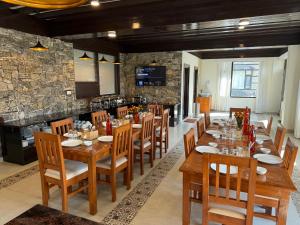 a large dining room with wooden tables and chairs at Manali Se - Your Home in the Pines in Jagatsukh