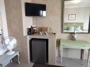 a room with a fireplace with a mirror and a table at Stone Crown Manor B&B in Mossel Bay