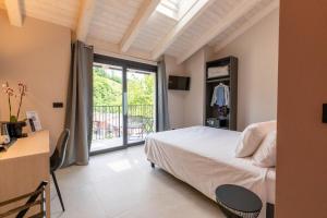 a bedroom with a bed and a balcony at La Collina delle Rondini in Boves