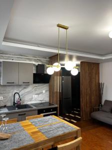 a kitchen with a table and some lights in a room at Cozy Corner Apartments in Bistriţa