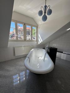 a bathroom with a white bath tub and windows at Apartmán Bonaparte in Loket