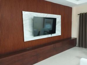 a television on a wall in a hotel room at Gnaanams Hotel and Restaurant in Jaffna